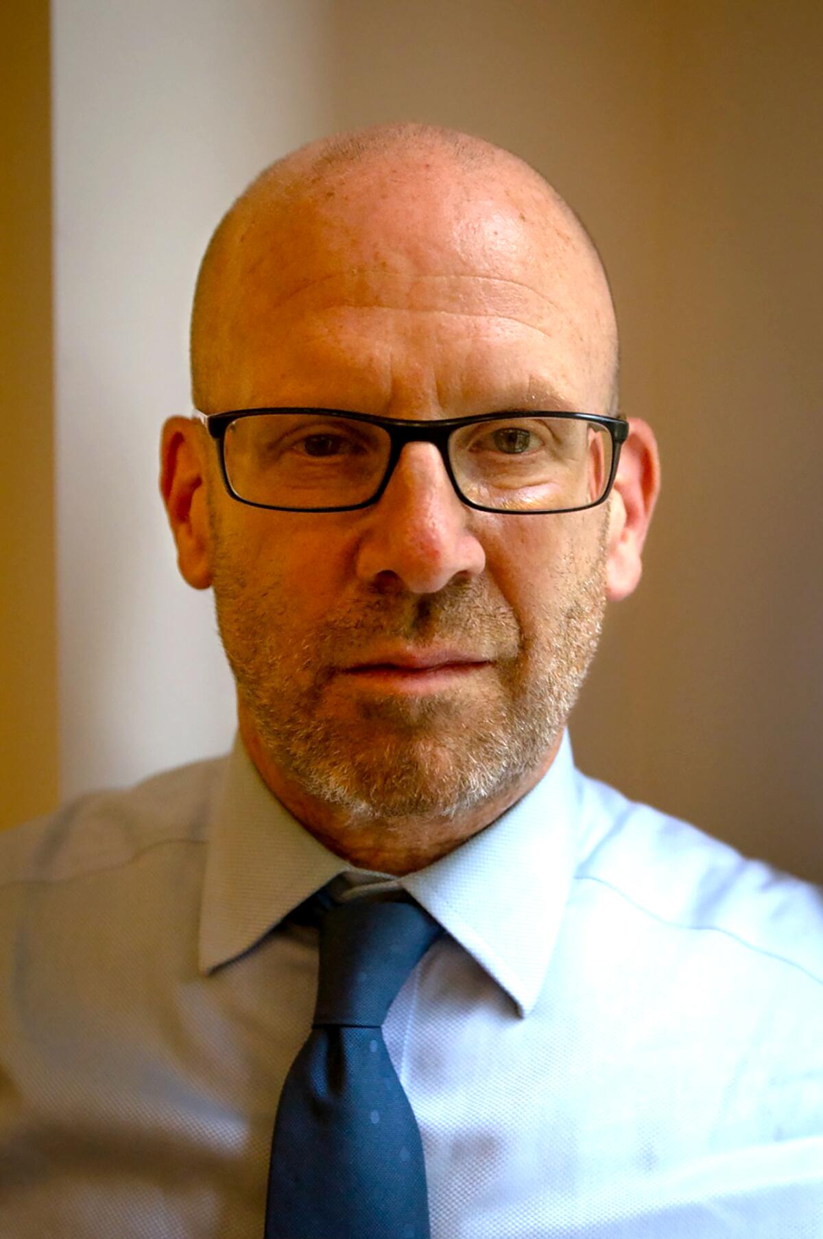 Author Jonathan M. Metzl, in glasses, a tie and collared shirt, looks straight into the camera.