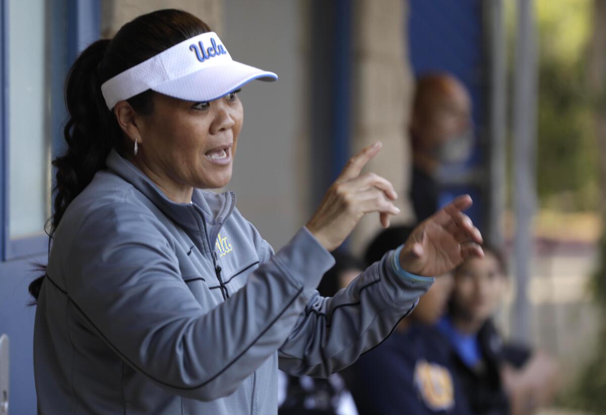 UCLA softball coach Kelly Inouye-Perez instructs a pitcher in the bullpen.