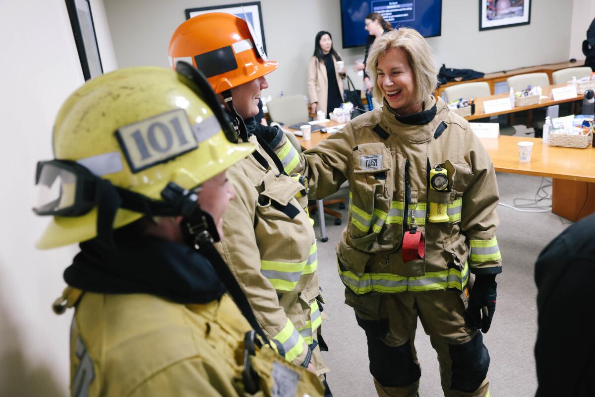 Supervisor Janice Hahn, left, tries on the personal protective equipment. 