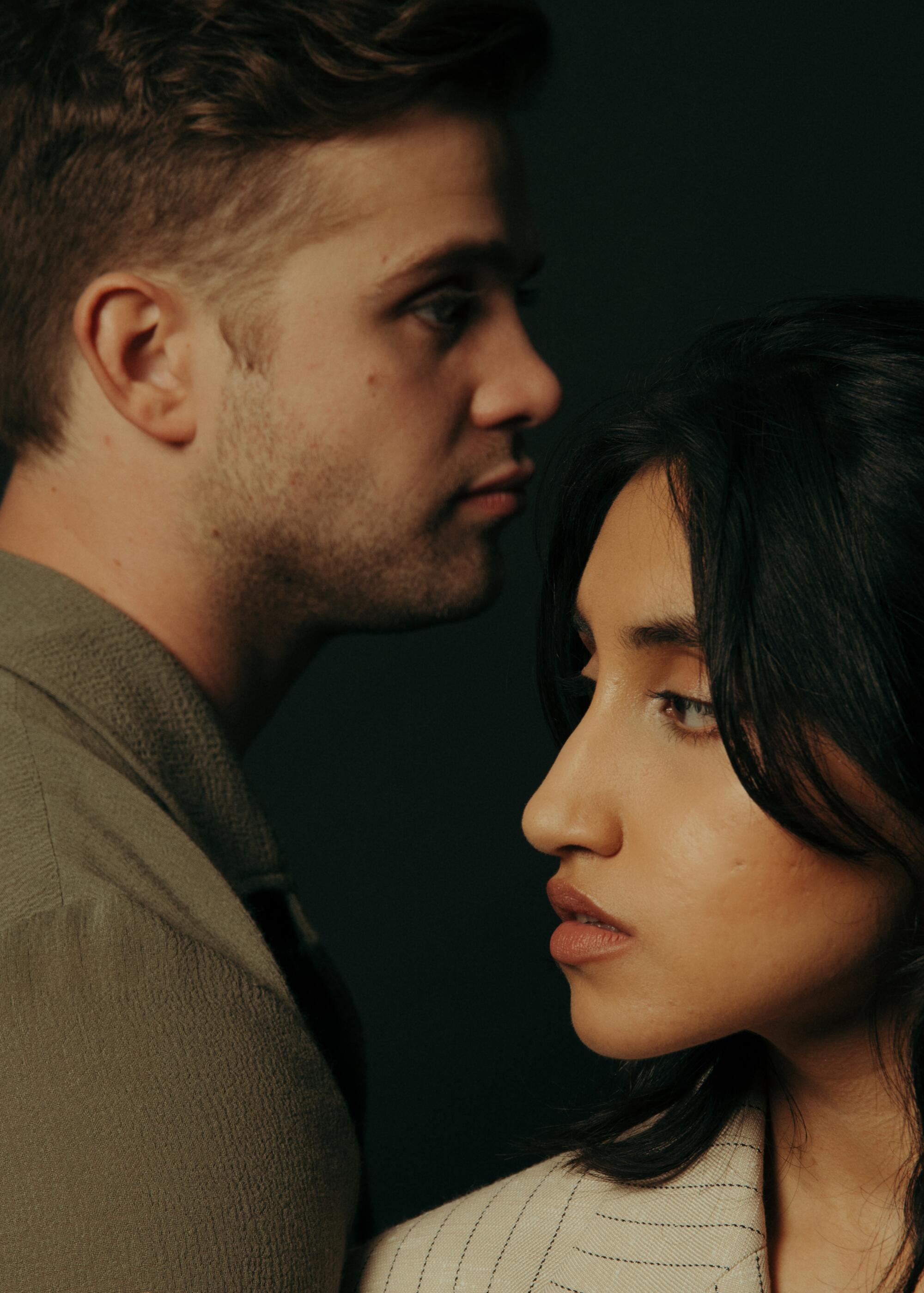 A man stands looking over a woman who is facing his shoulder.