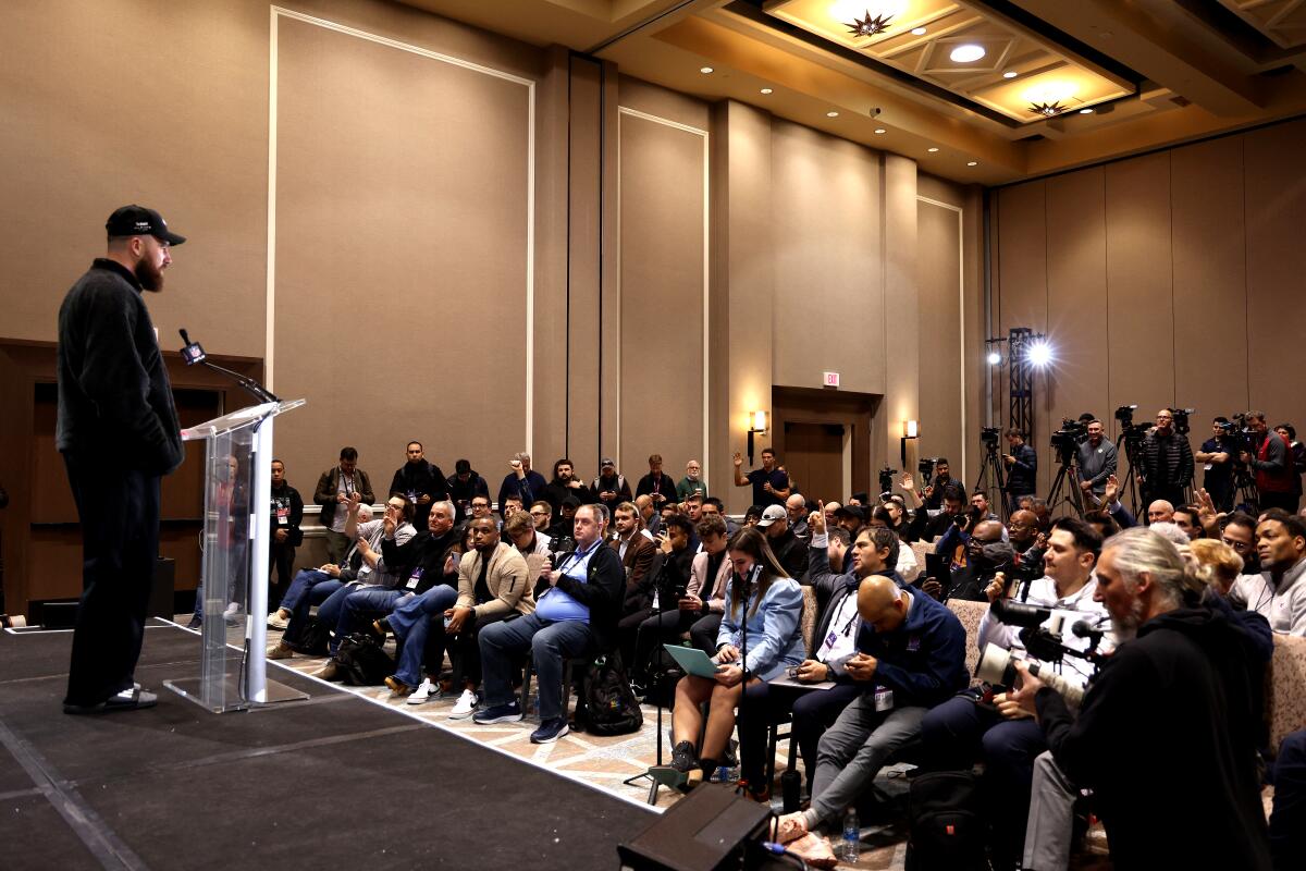 A man at a podium looks out at an audience