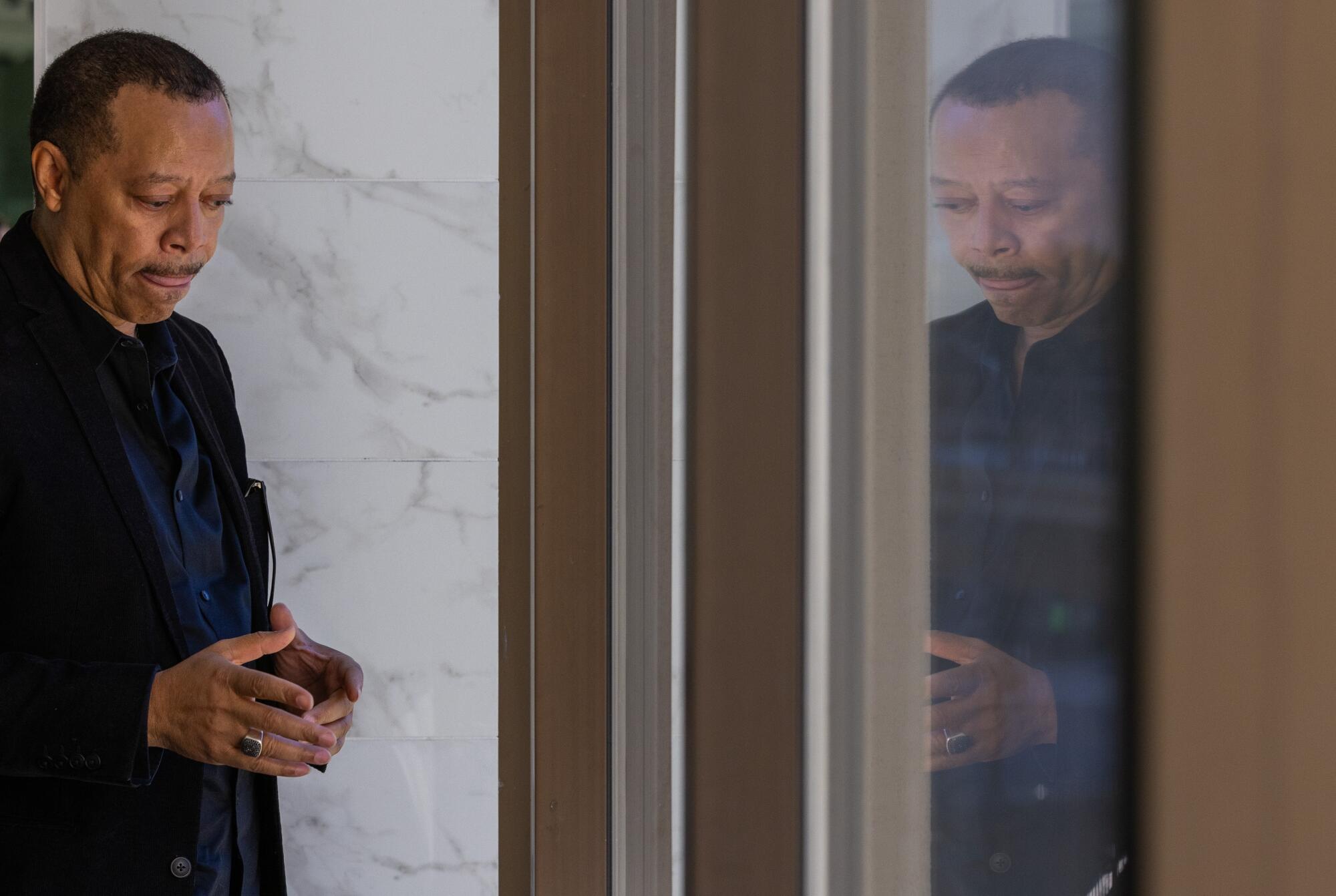 Dennis L. Smith stands near a reflection of him.