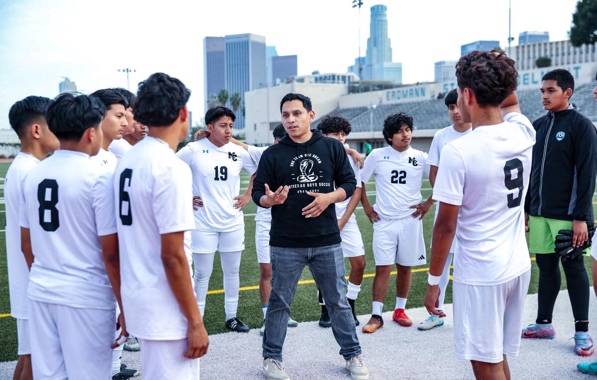 Coach Eder Puga Garcia, 27, talks to his Contreras soccer players. 