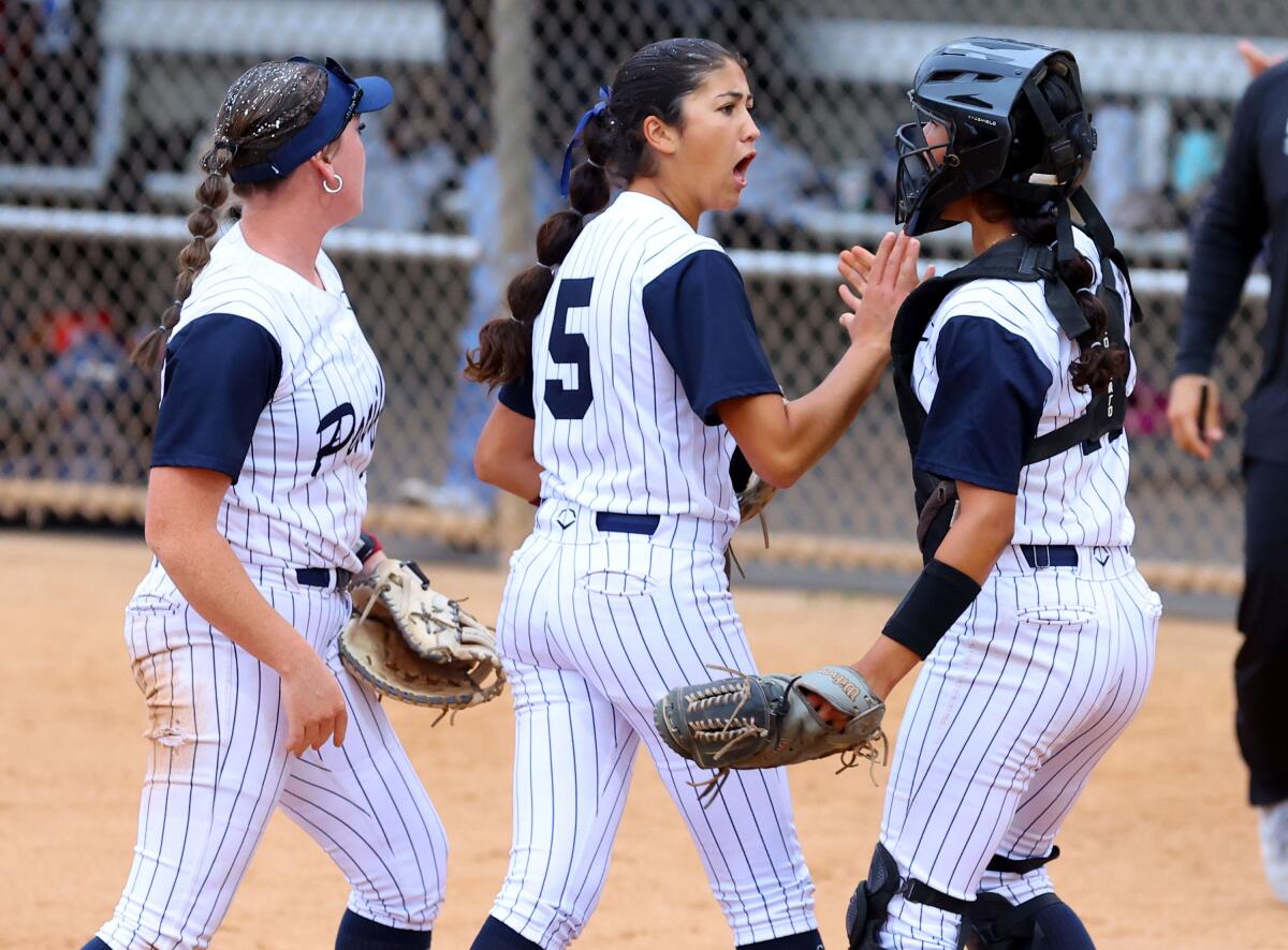 Pacifica High pitcher Brynne Nally (5) is congratulated by catcher Catherine Benitez after retiring the side.