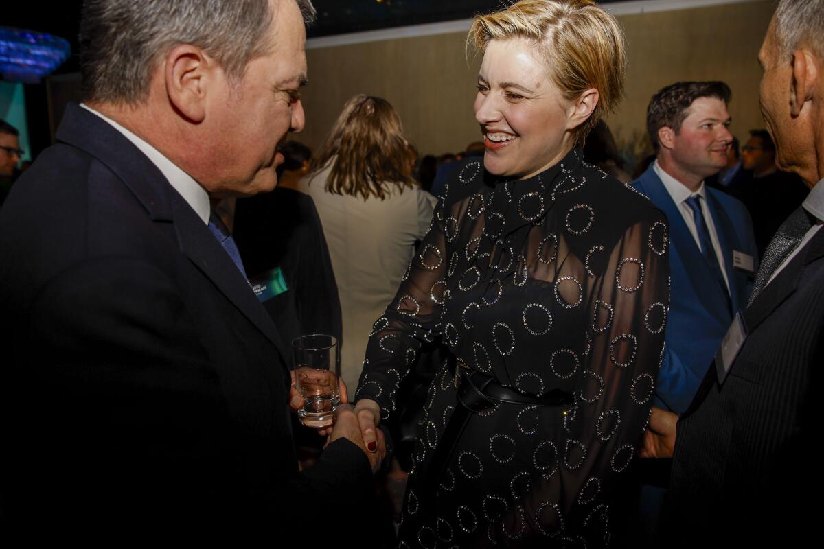 A blond woman smiles in greeting.