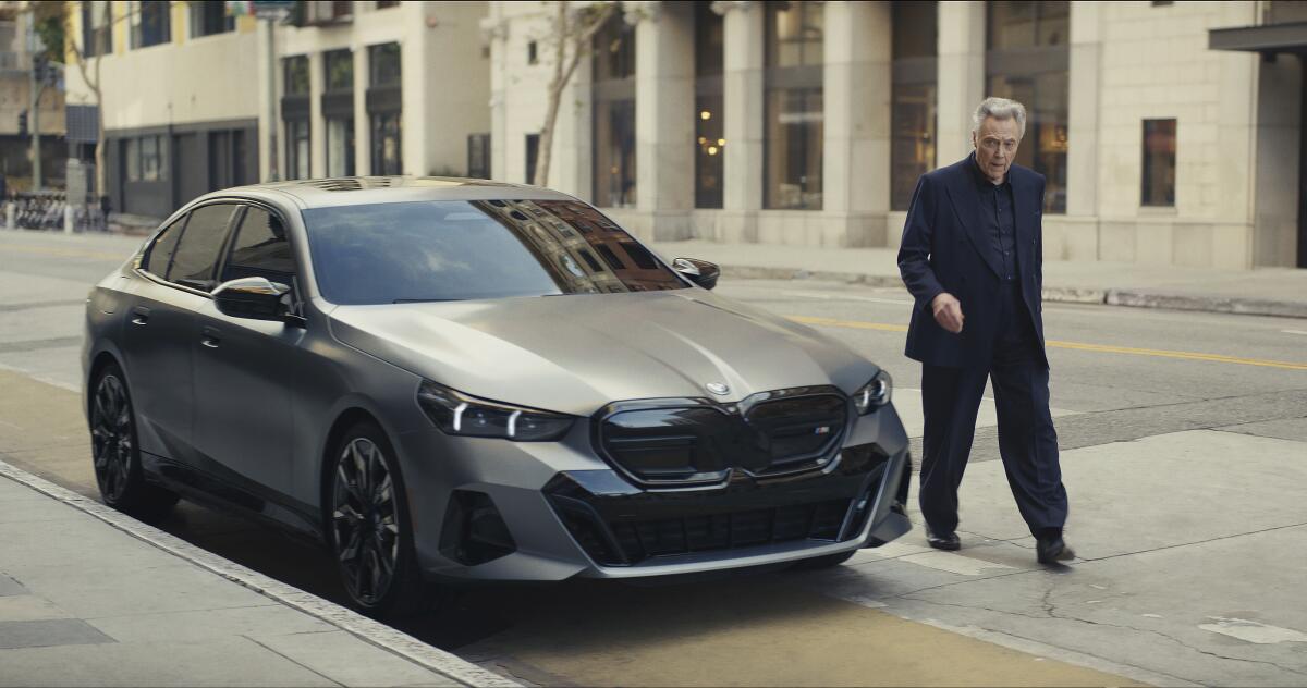 A man walks near a car.