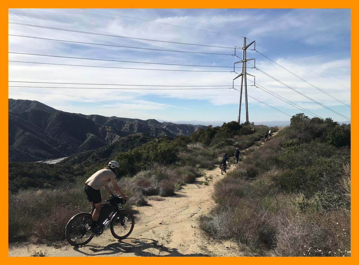 A biking group rides along a dirt path