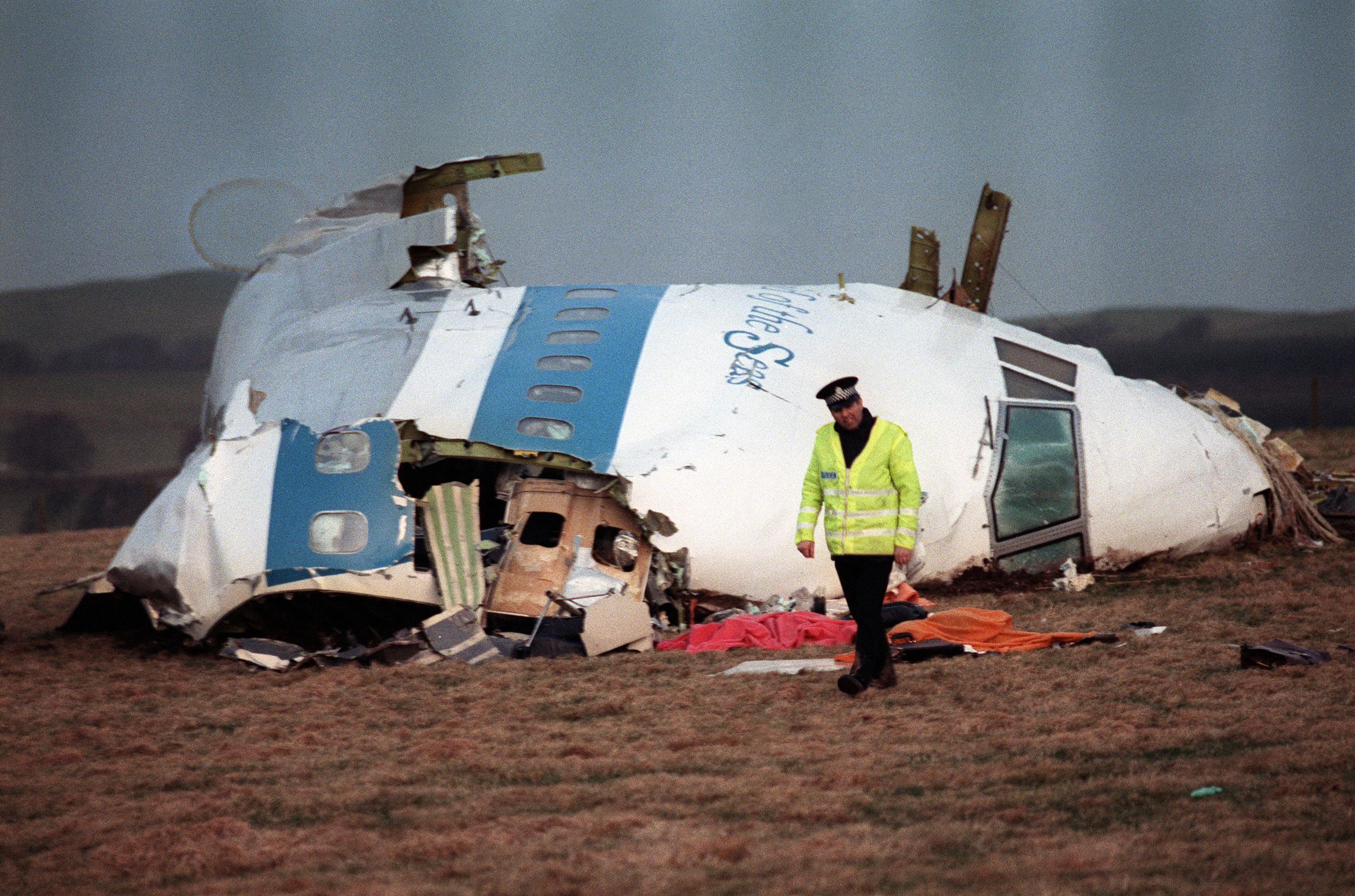 A police officer guards the destroyed remains of the Boeing 747 after the mid-air explosion