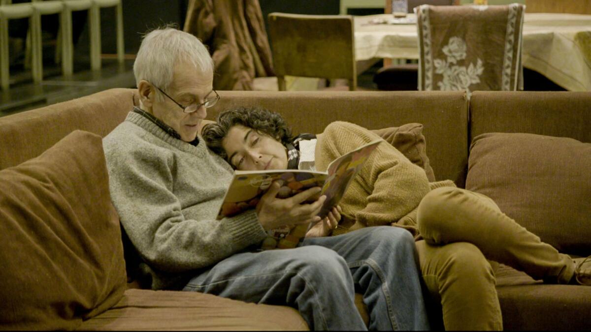 A still shows the elderly Augusto Góngora paging through a book as his wife, Paulina Urrutia, leans tenderly against him.