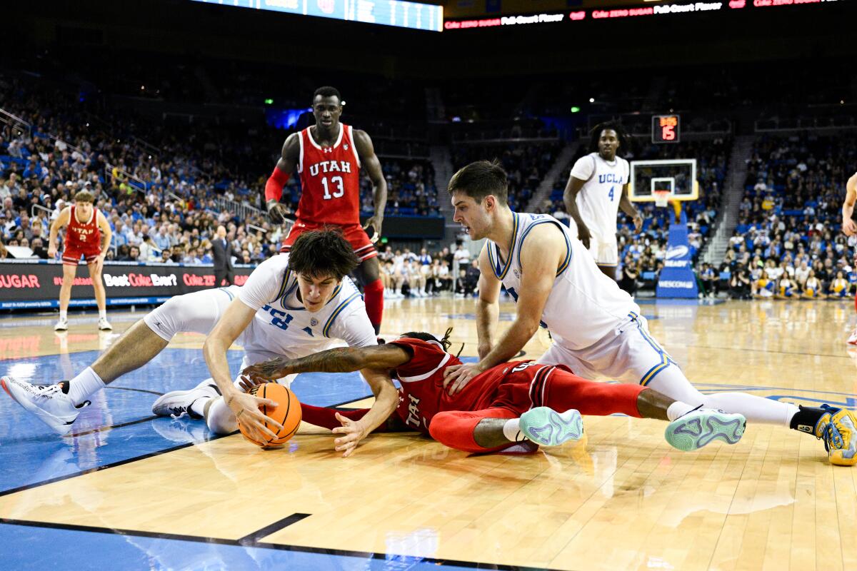 UCLA forward Berke Buyuktuncel, left, and guard Lazar Stefanovic, right, battle Utah guard Deivon Smith.