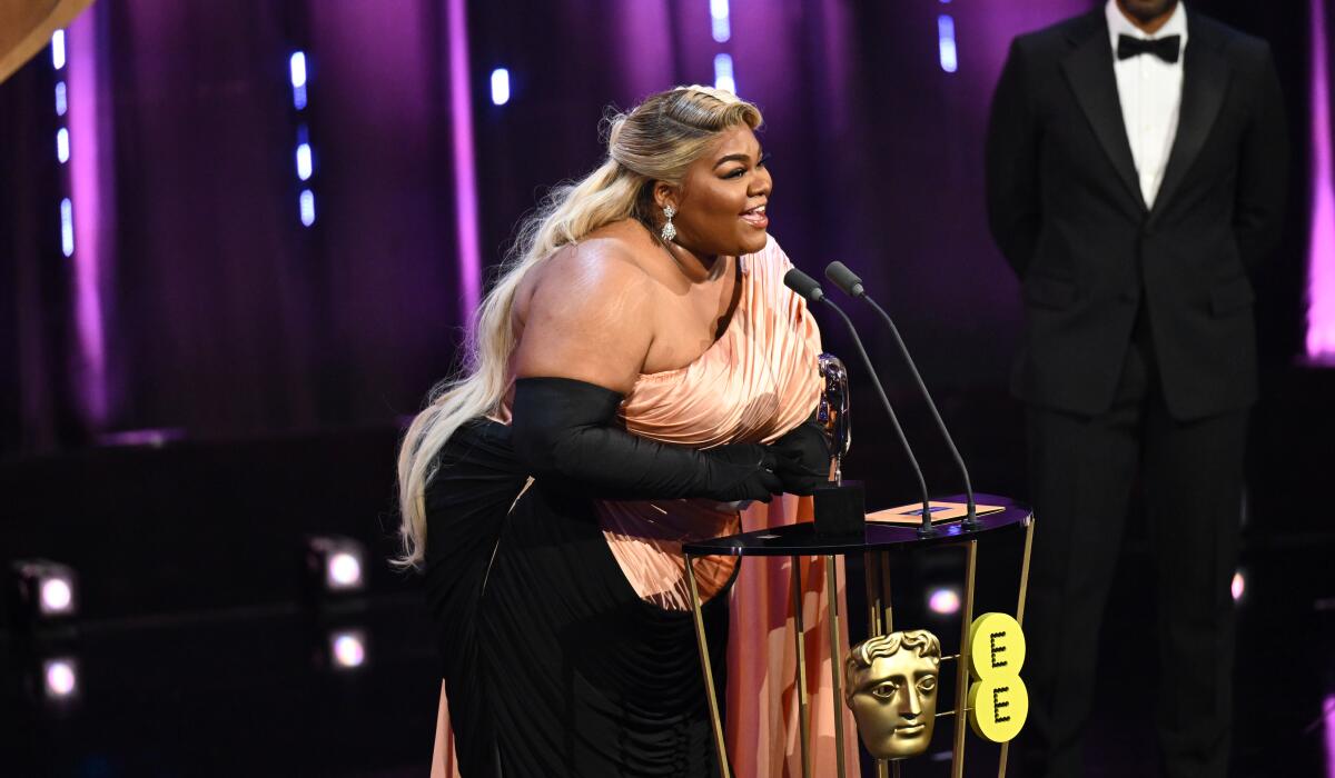 A woman happily accepts an acting award.