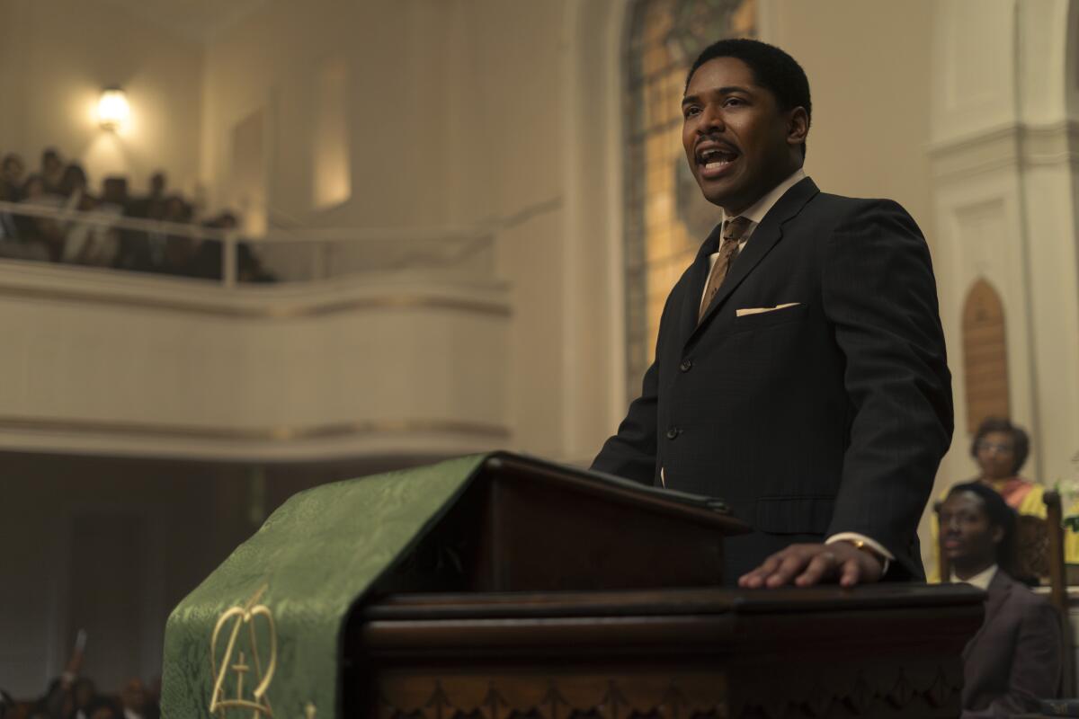 A man in a suite at a church pulpit.