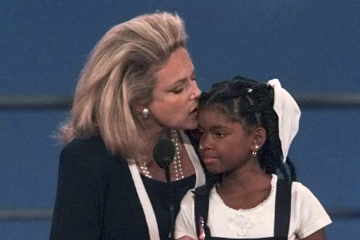 Mary Fisher kisses 12-year-old Hydeia Broadbent as they were both addressing the evening session of the 1996 GOP convention