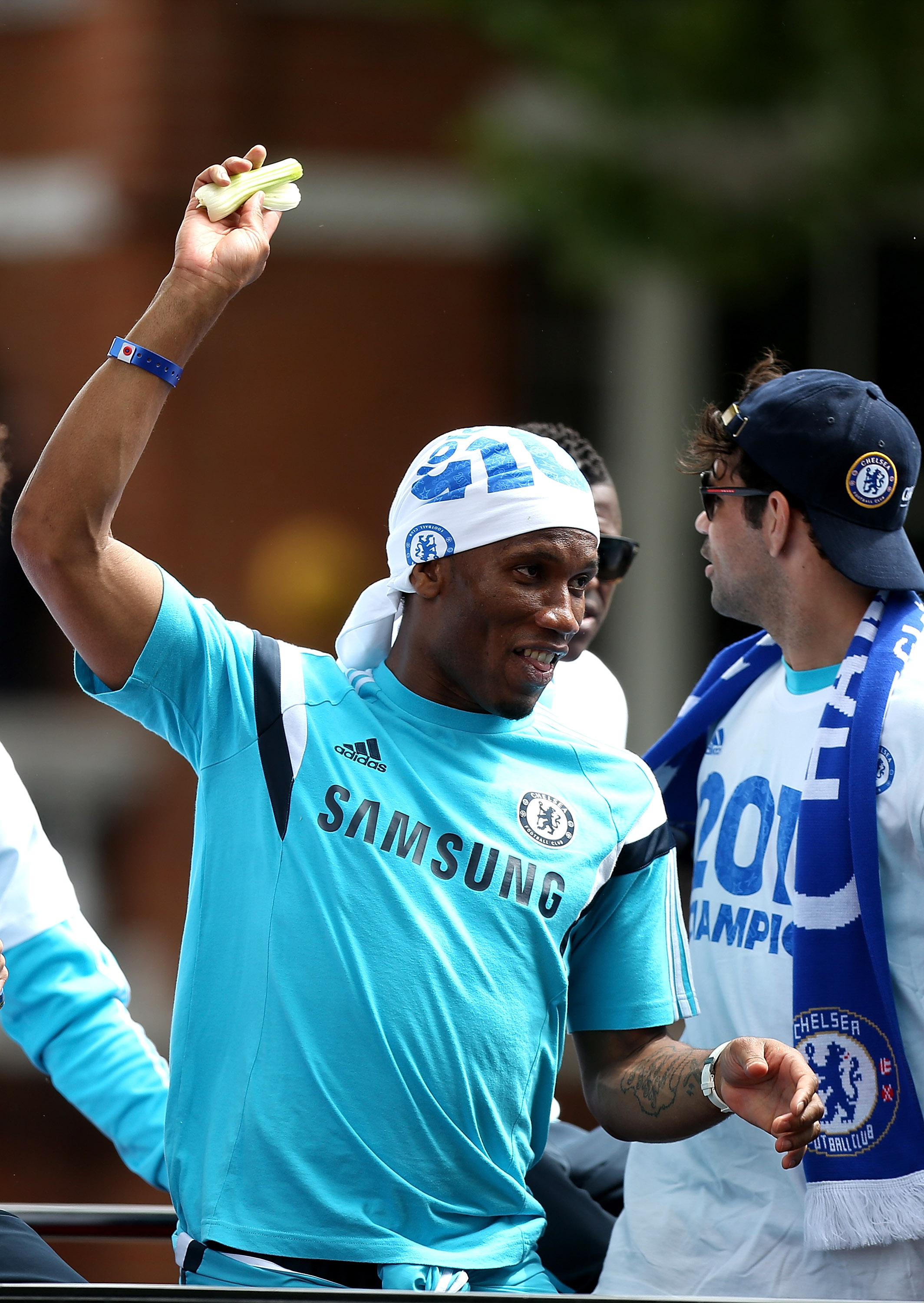 Chelsea legend Didier Drogba hilariously lobbed the green vegetable back at fans from an open-tip bus