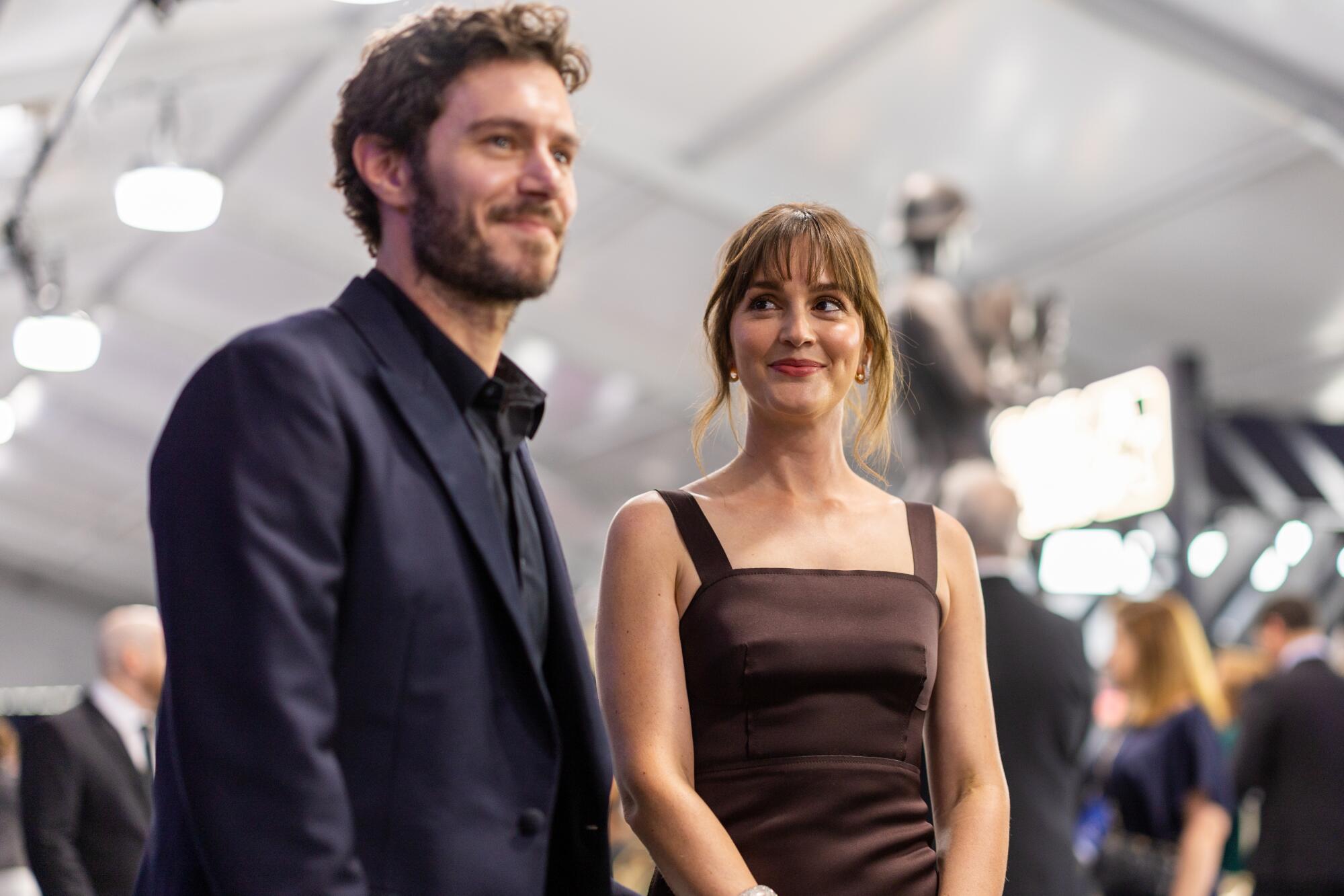 Leighton Meester, in a brown dress, looks lovingly at Adam Brody, in a blue tux, at the SAG Awards.