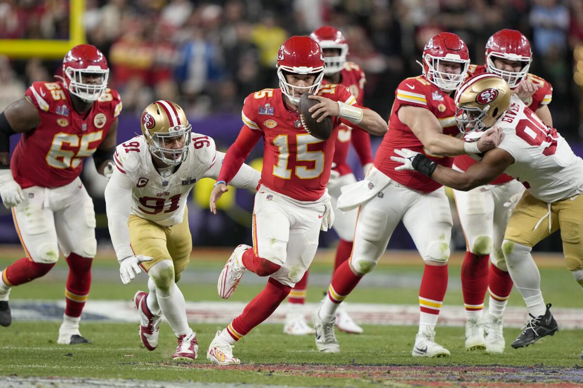 A football player runs while holding the ball during the Super Bowl.