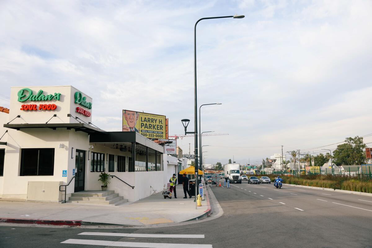 Cars pass along Crenshaw Boulevard in front of Dulan's