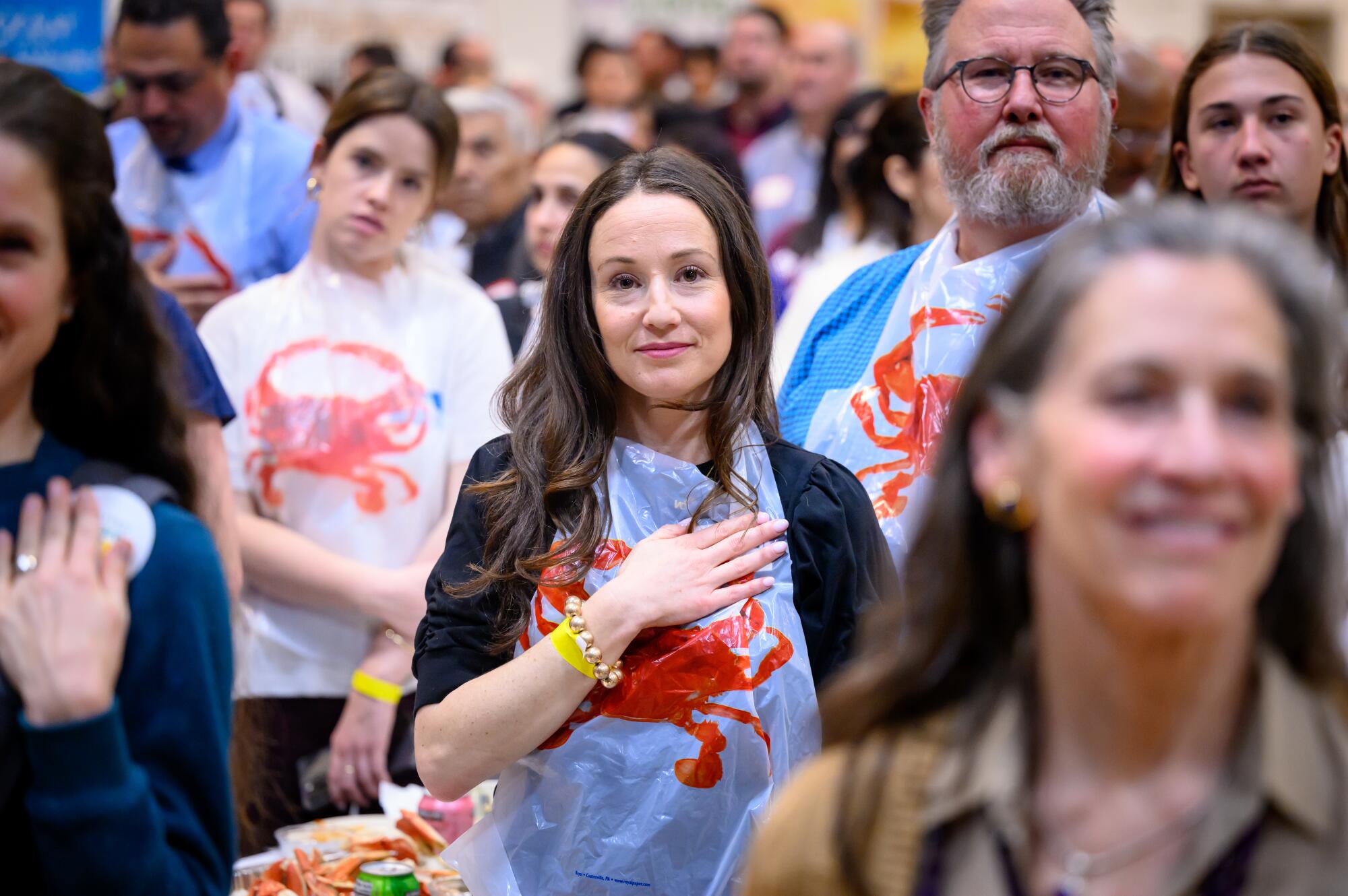 A woman holds a hand over her heart at a crab-eating event.