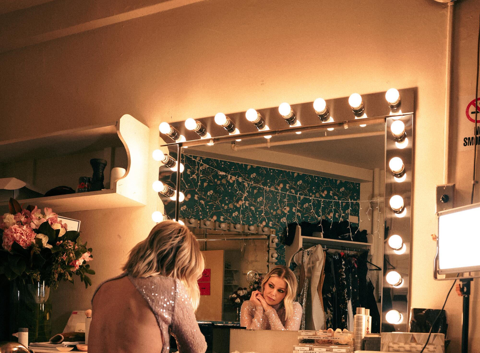 Ariana Madix looks at her reflection in a dressing room mirror