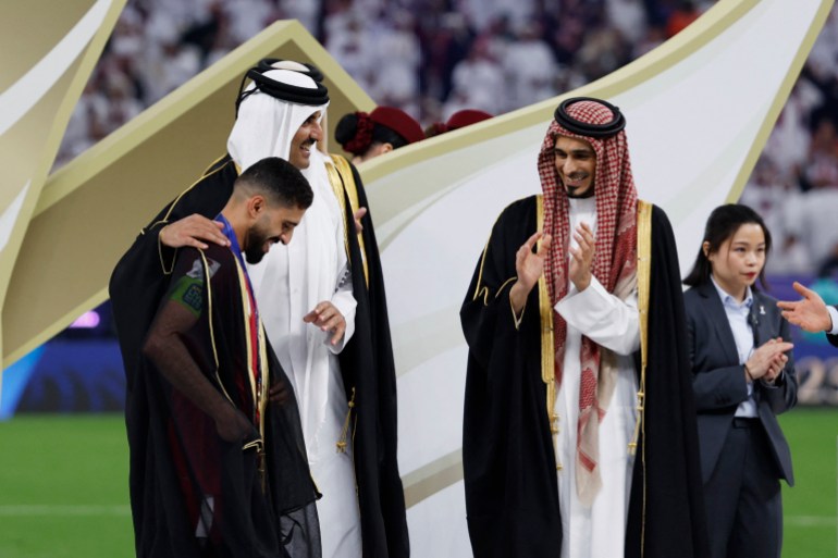 Soccer Football - AFC Asian Cup - Final - Jordan v Qatar - Lusail Stadium, Lusail, Qatar - February 10, 2024 Qatar's Hassan Al-Haydos with Qatar's Emir, Sheikh Tamim bin Hamad al-Thani after winning the AFC Asian Cup REUTERS/Thaier Al-Sudani