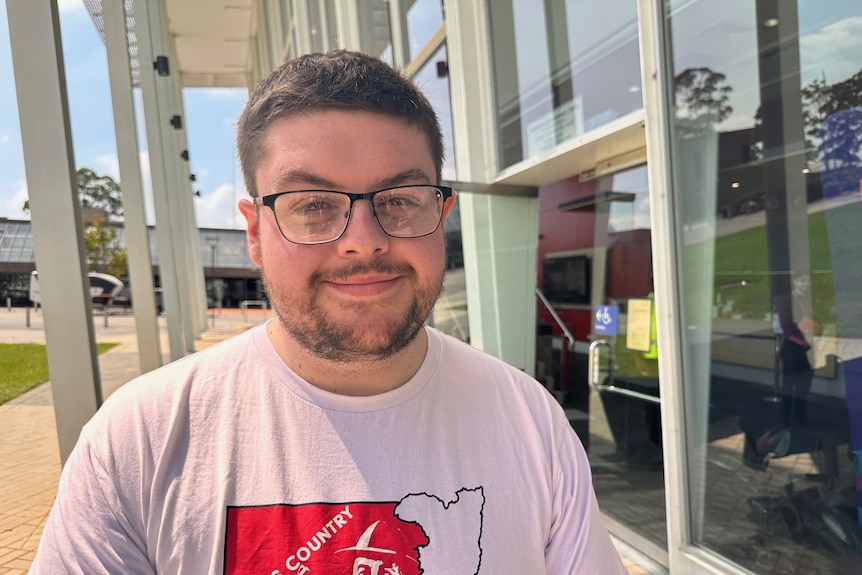 A smiling young man wearing a t-shirt.