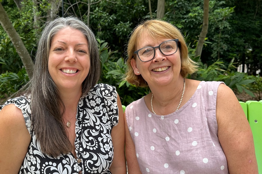 Bonnie Searle and Karen Thorpe sitting on a green bench