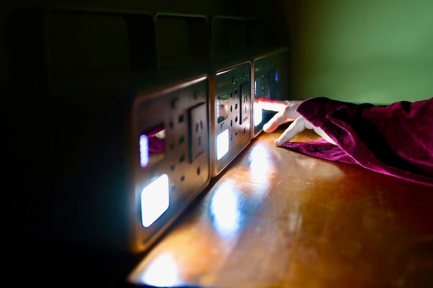 hand switching on three portable power stations 