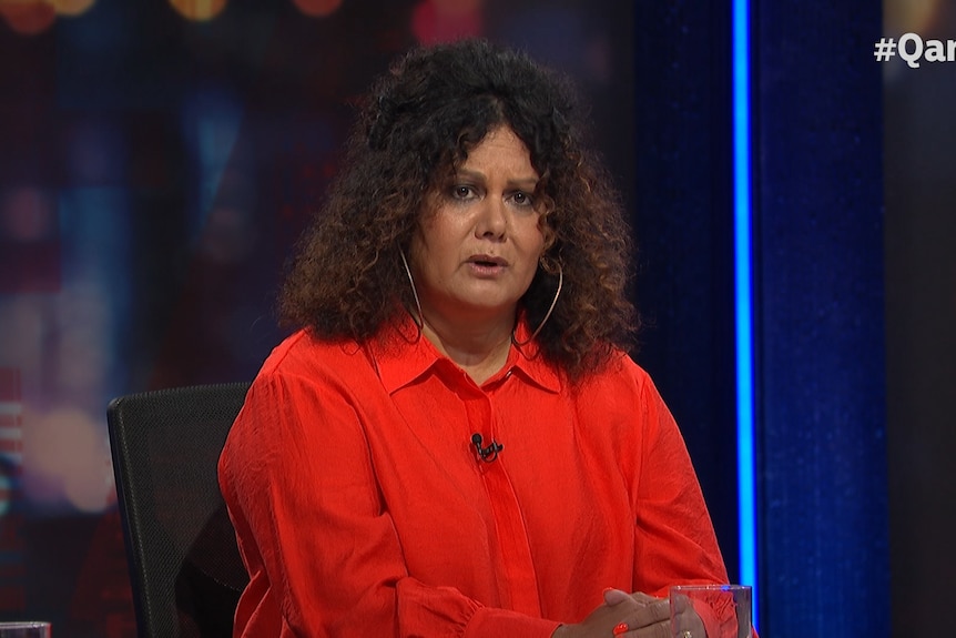 Image shows an Indigenous woman wearing a red jacket