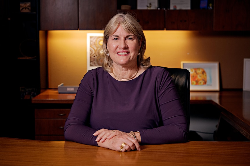 Eva Lawler sitting behind a desk in a dark parliamentary office.