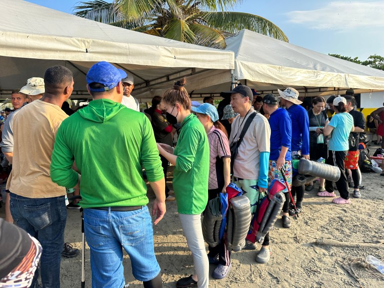 A line of Chinese migrants waiting to depart on boats in Necoclí-