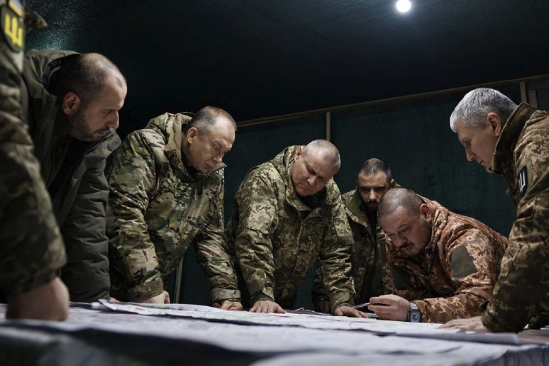 Ukraine's army chief in discussions with other senior officers near the front line in Avdiivka, They are gathered around a table looking at plans