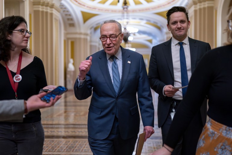 Chuck Schumer speaks to reporters as he walks through the halls of Congress. 