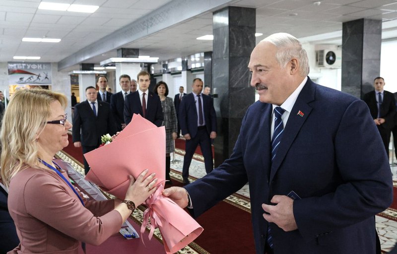 Belarusian President Alexander Lukashenko presents flowers to a member of a local electoral commission during the Belarusian parliamentary elections at a polling station in Minsk, Belarus, on Sunday. Photo by Belarusian Presidential Press Service/EPA-EFE