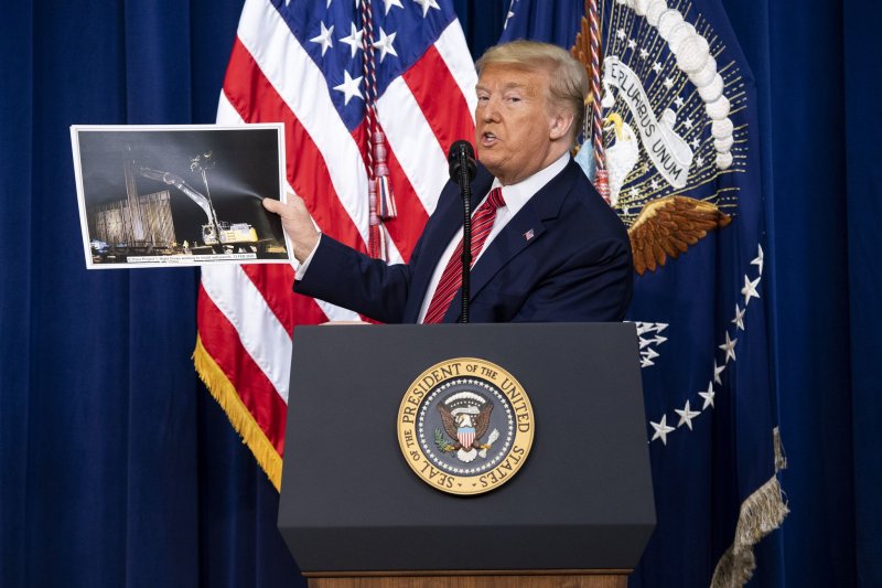 Former President Donald Trump holds up a photo of the border wall as he speaks to the National Border Patrol Council at the White House on February 14, 2020. File Photo by Kevin Dietsch/UPI