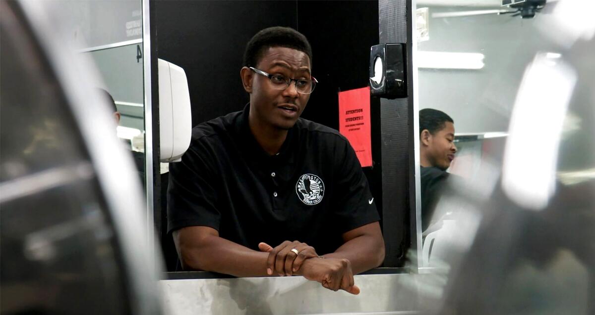 A man stands in a shop with many mirrors in "The Barber of Little Rock."