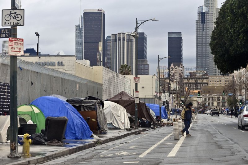 A homeless man walks across the street in Los Angeles in February 2023. The U.S. Department of Housing and Urban Development said it has awarded a total of $4 million in grants to 11 grantees for them to carry out a multitude of tasks designed to ultimately "help communities meet their housing needs." File Photo by Jim Ruymen/UPI