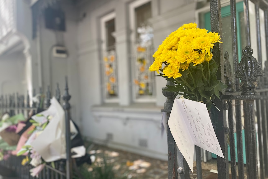 Flowers left on a gate outside a house