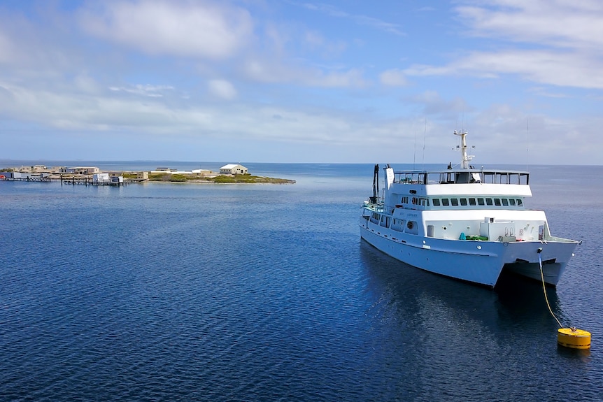 A sight-seeing boat near a small island.