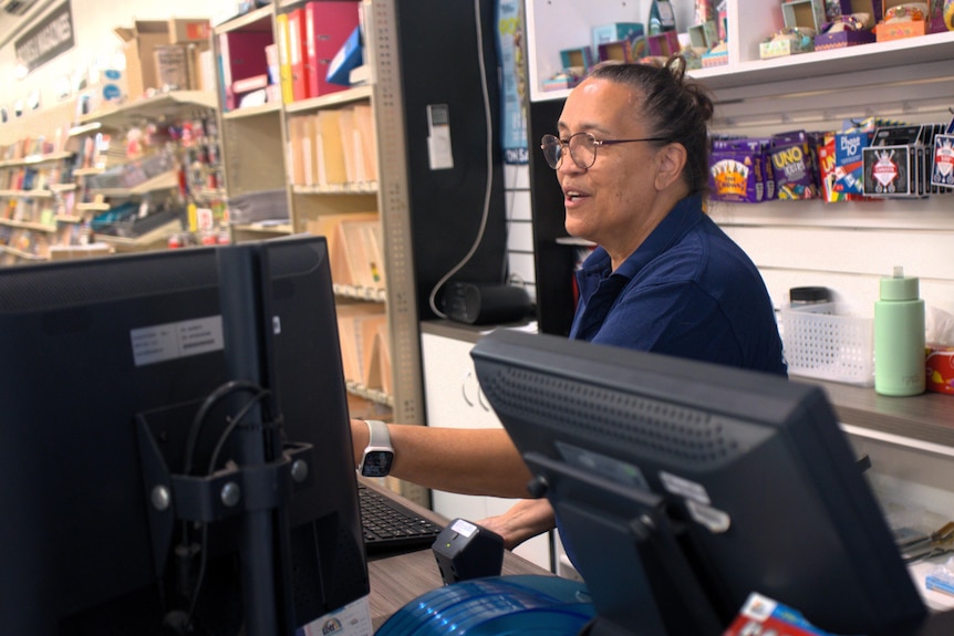 A woman at a newsagency till