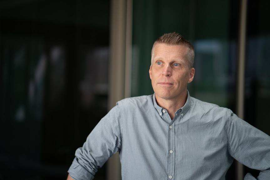 A headshot of a white man with a collared shirt.