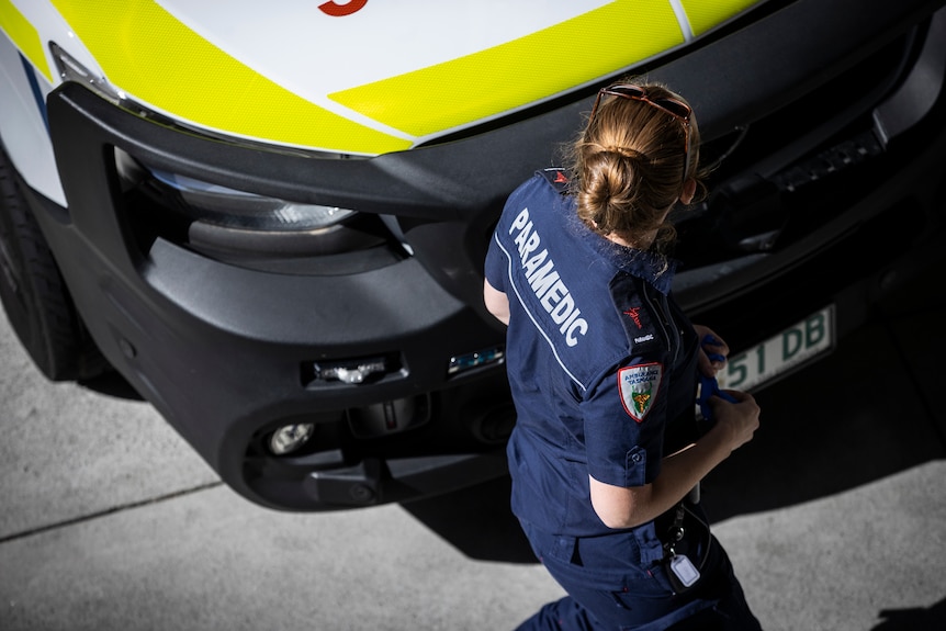 A female paramedic walks past an ambulance parked outside the Royal Hobart Hospital.