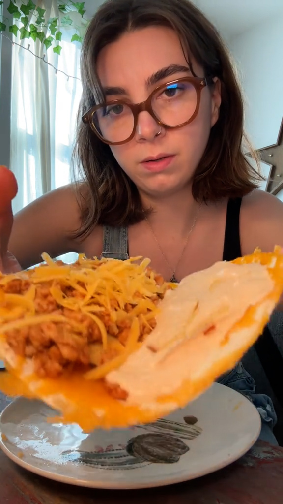 She wrapped up the taco after another layer of cheddar cheese