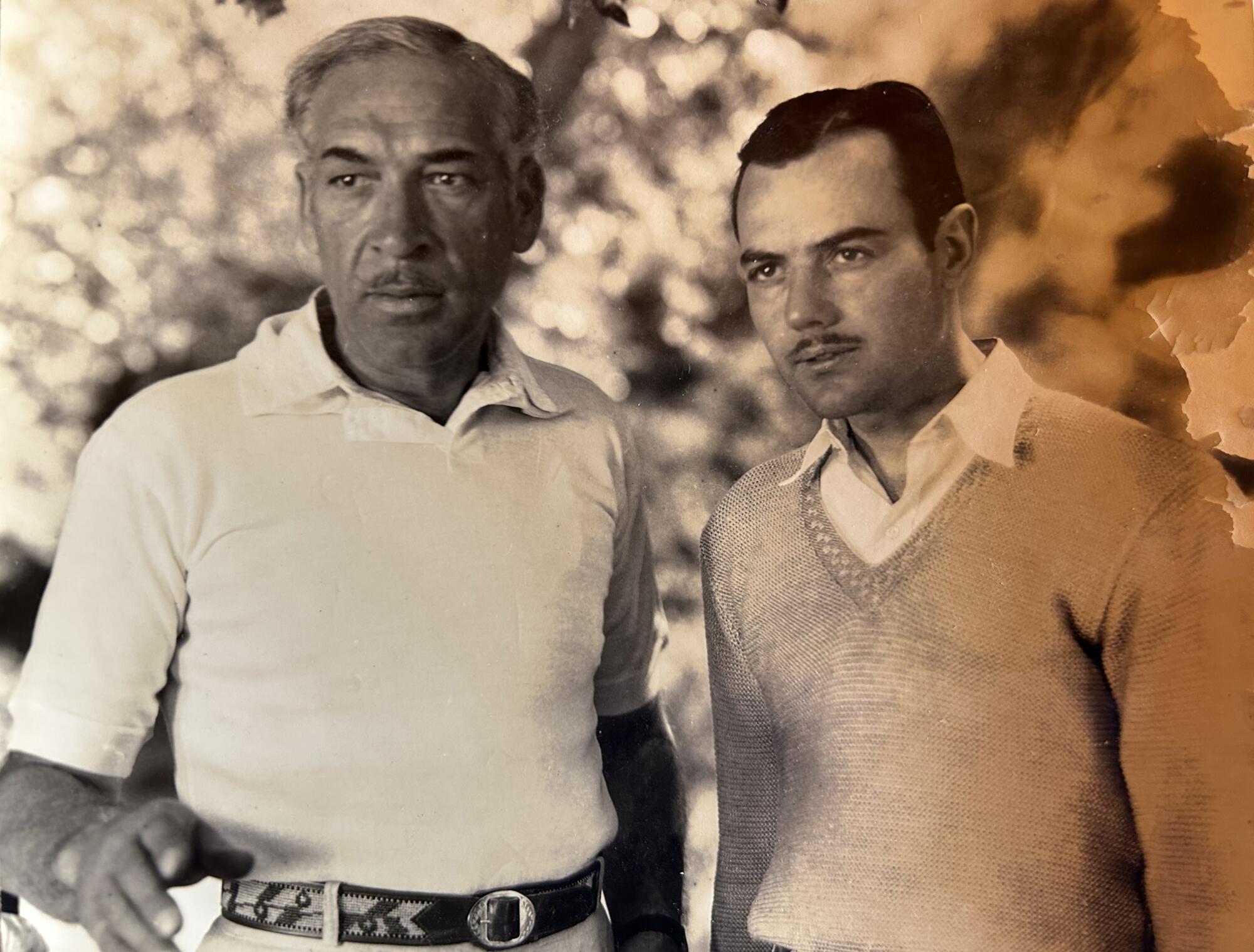 Two men, casually dressed, looking toward the camera in a photo from the 1950s.