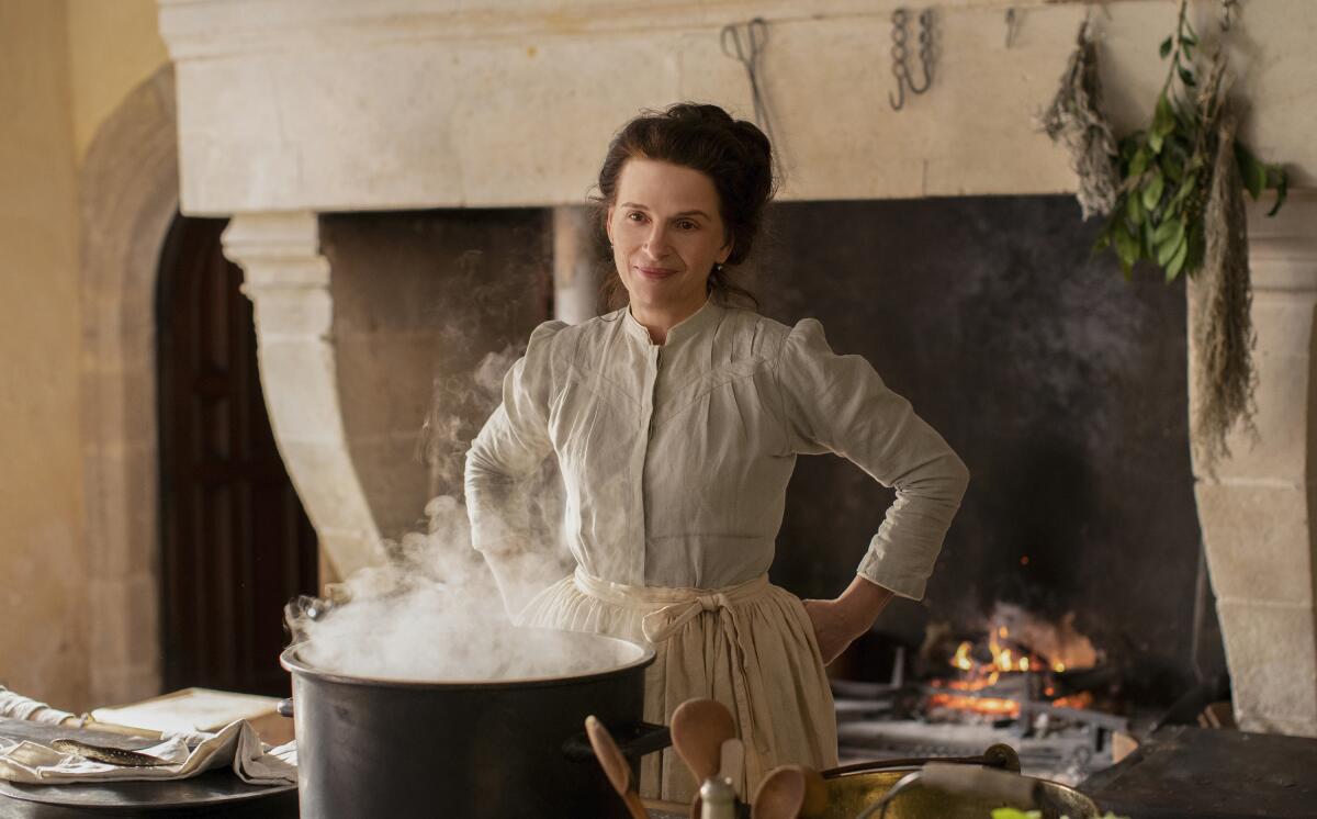 A woman stands over a pot that's billowing steam