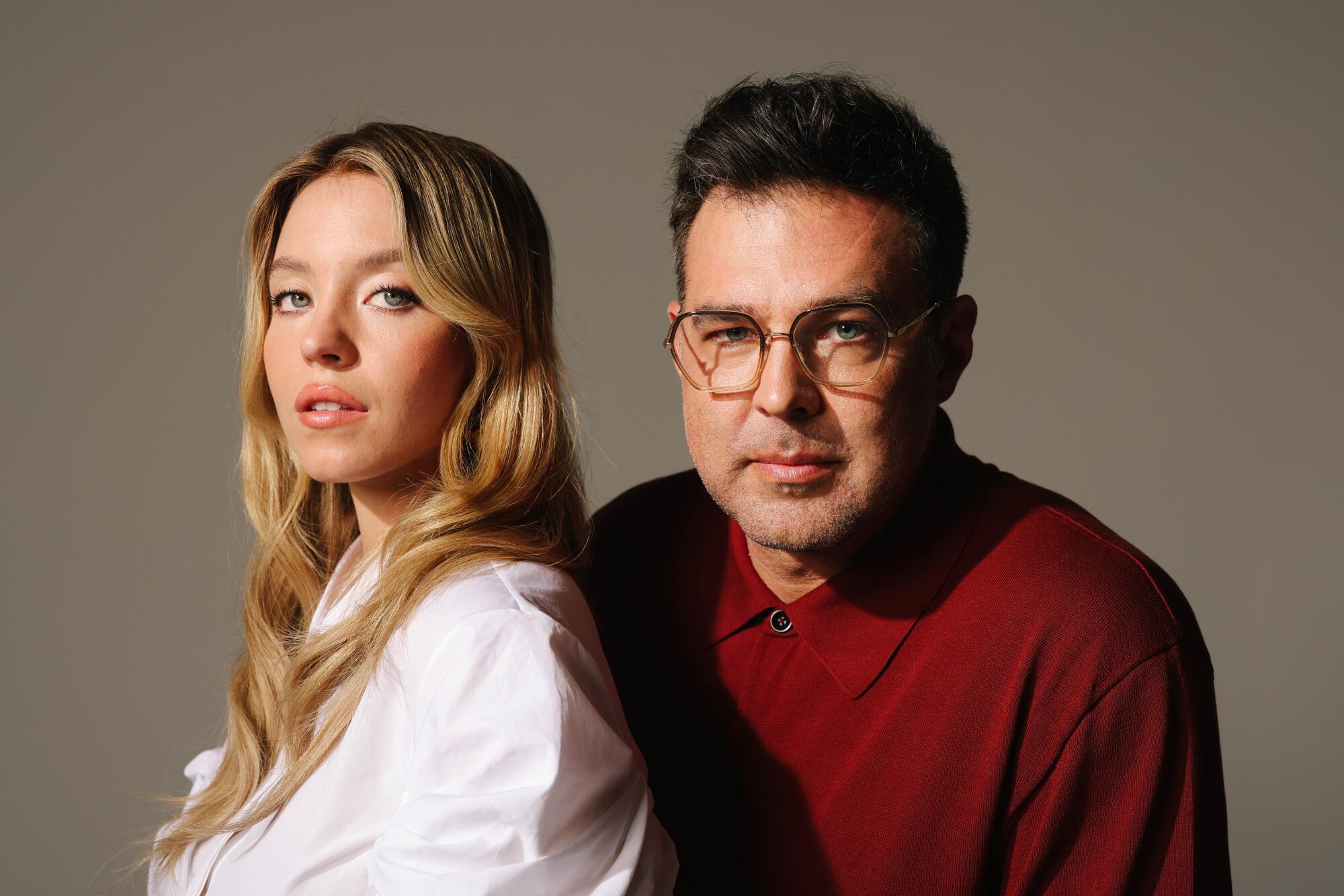 A woman and a man in a red shirt pose for the camera.