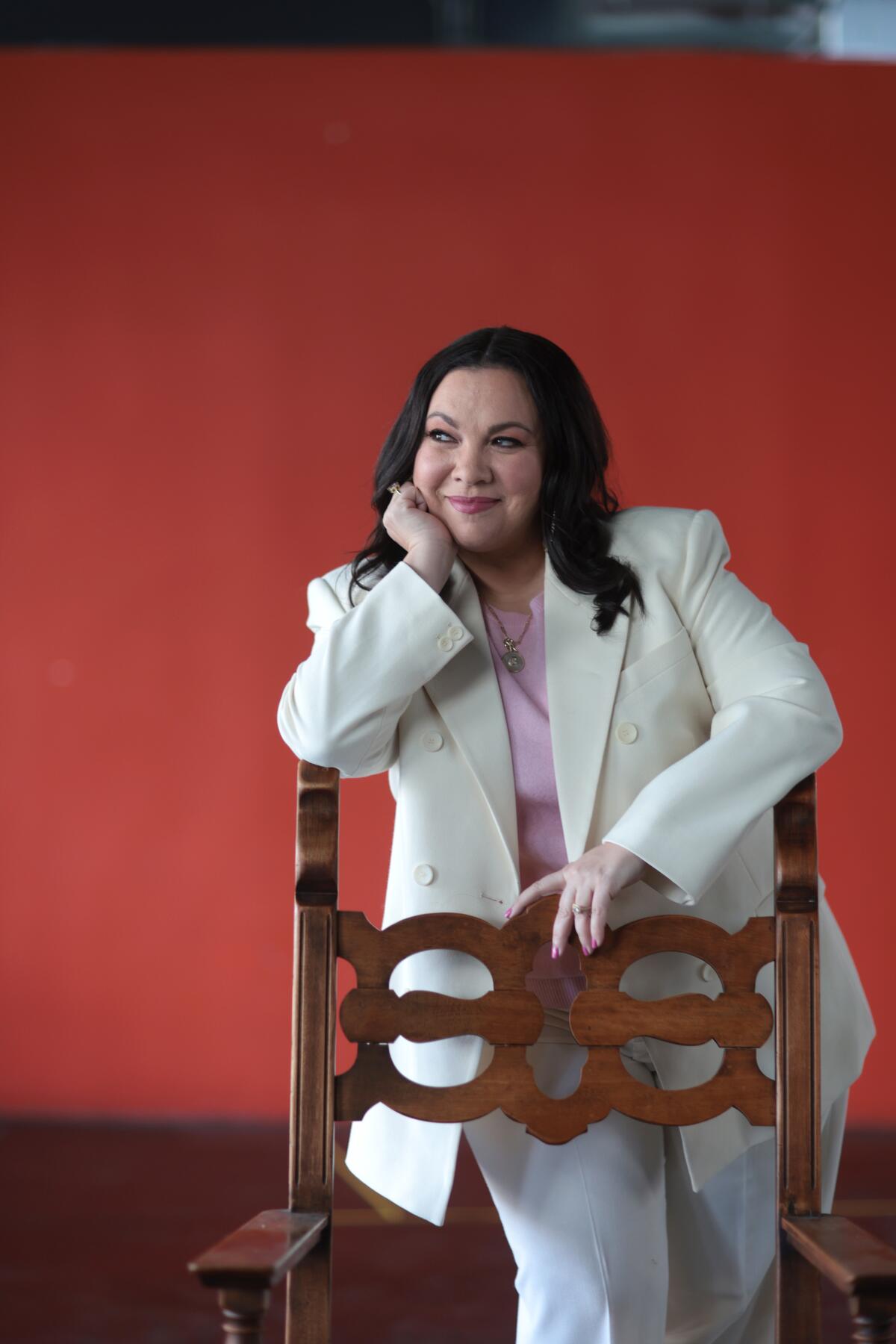 A woman smiling behind a chair