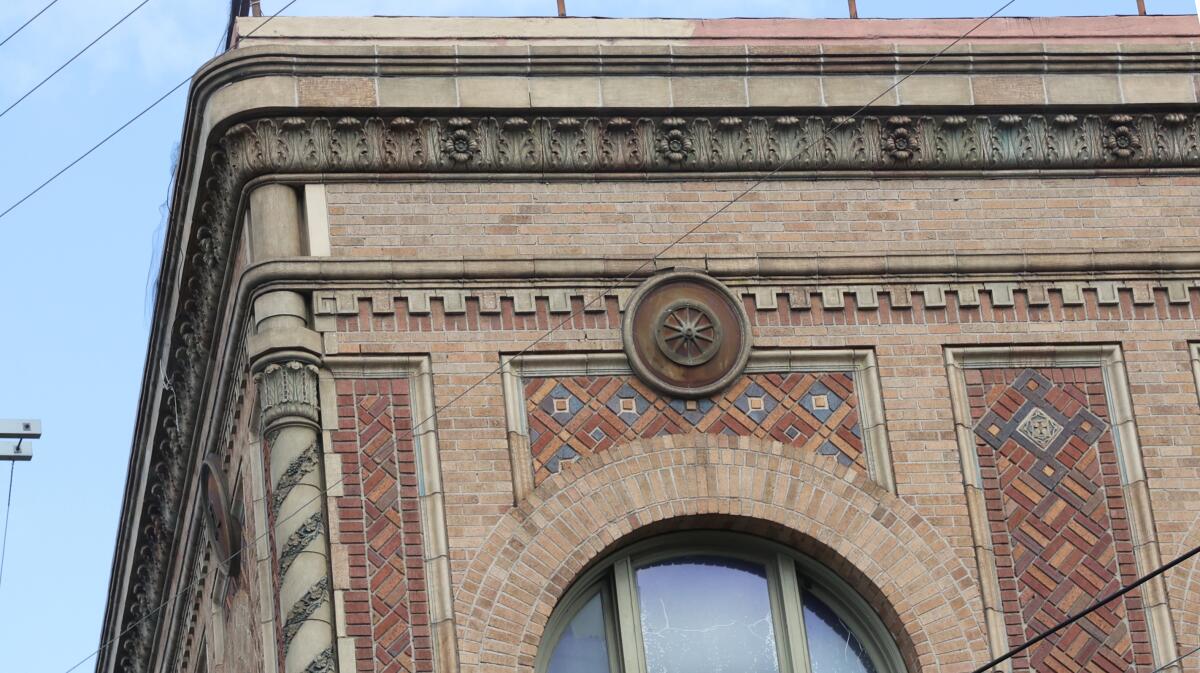 A close up on the corner of a buildings reveals colorful tile and trim.