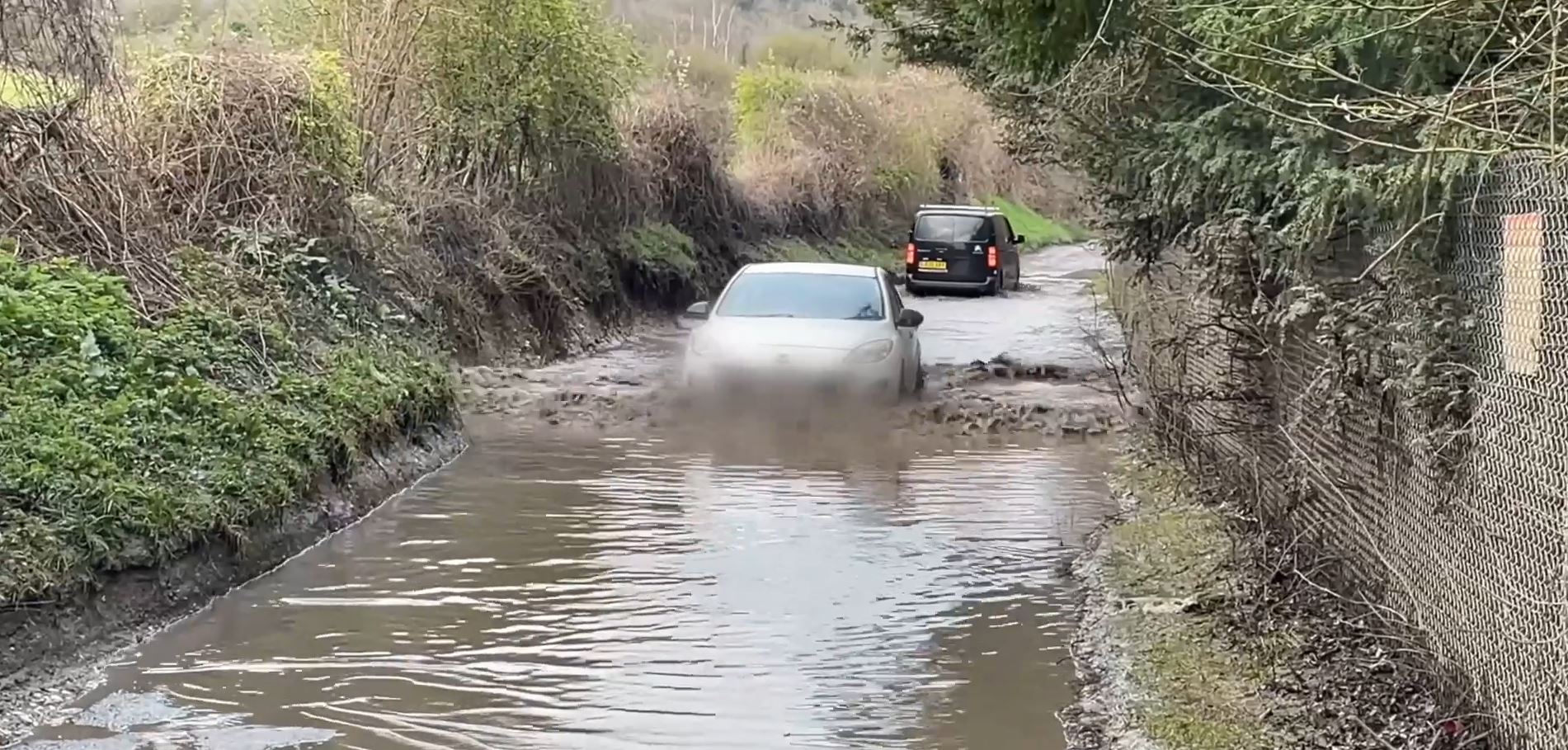 Cars do try and pass through the muddy depths near Rochester, Kent, but flood waters go up to the bumpers