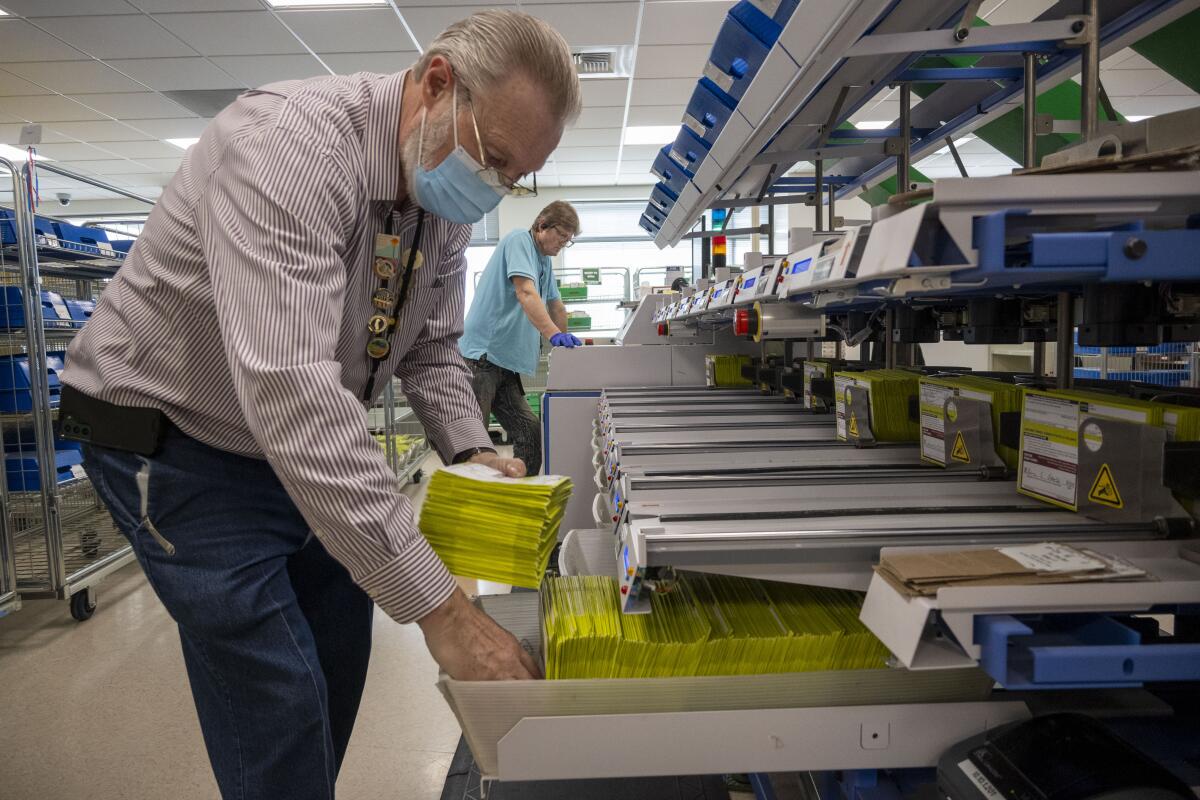 Louis Campbell puts ballots into baskets at the San Joaquin County Registrar office in downtown Stockton.