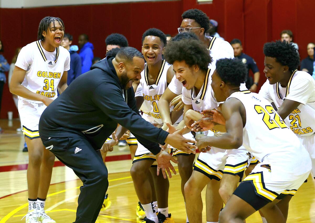 King/Drew coach Lloyd Webster celebrate with his players after winning City Section Open Division championship.